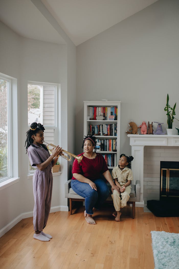 Mother and daughters spending quality time indoors with a trumpet, creating family memories.