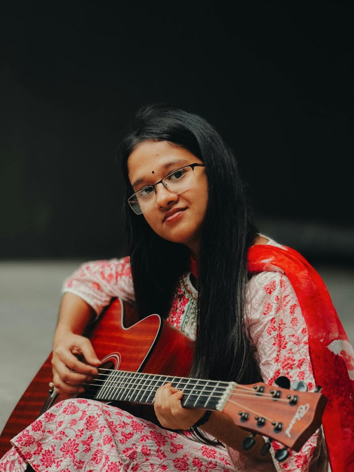 young-woman-playing-acoustic-guitar-indoors-32652414
